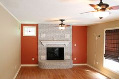 an empty living room with a fireplace and fan