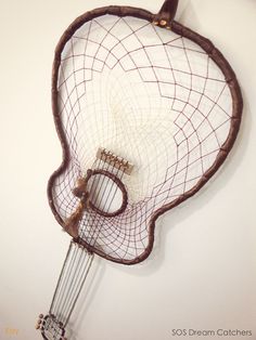 a string instrument hanging on the wall with strings attached to it's back end