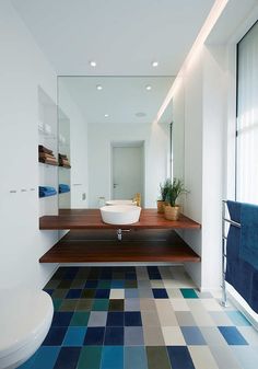 a bathroom with blue and green tiles on the floor