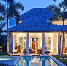 the pool is surrounded by palm trees and lawn chairs, as well as an outdoor living area