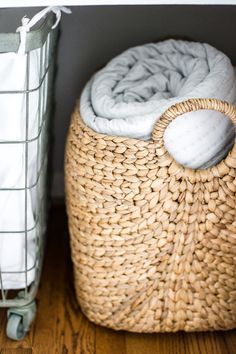 a wicker basket next to a white blanket