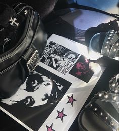 a black purse sitting on top of a table next to shoes and a book with stickers