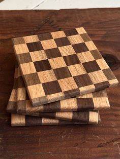 three pieces of wood are stacked on top of each other in the shape of chess boards