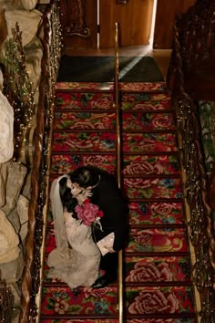 a bride and groom are kissing on the stairs