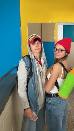 two young people standing next to each other in a room with blue and yellow walls