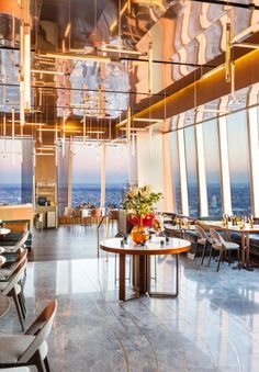 a dining room with tables and chairs overlooking the city from high up in the sky