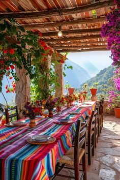 an outdoor dining area with colorful table cloths and potted plants on the patio