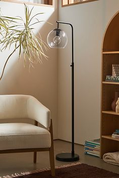 a living room with a chair, lamp and bookshelf