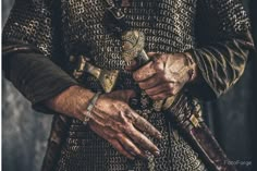 an old man wearing a gold and black outfit with his hands on his belt,