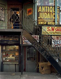 an old building with signs on the outside and stairs leading up to it's second floor