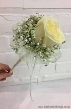 a white rose with baby's breath tied to it