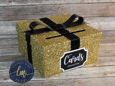 a gold glitter gift box with black ribbon