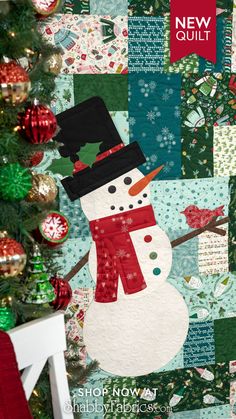 a quilted snowman is on display in front of a christmas tree