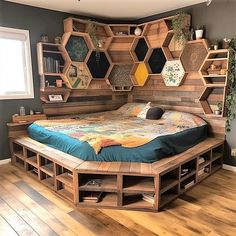 a bed made out of pallet wood with shelves on the wall above it and a blue bedspread