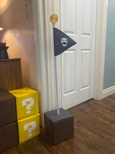 a flag pole next to some boxes on the floor in front of a white door