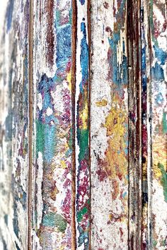 an old wooden door with peeling paint on the doors and bottom part of it painted in different colors