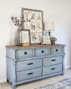 an old dresser is painted blue and has pictures on it with flowers in vases