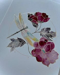 some flowers and a dragonfly on a piece of white paper with gold foiling