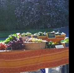 an assortment of fresh fruits and vegetables on display at a farmers'market table with price signs