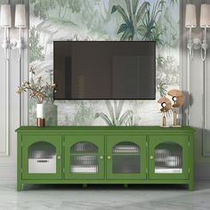 a green entertainment center with a flat screen tv mounted on it's sideboard