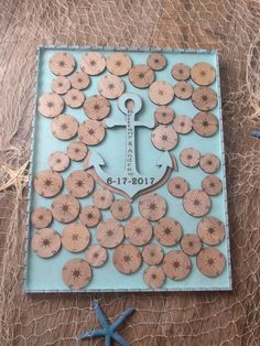 an anchor and starfish are placed on a piece of blue paper that has been cut out to look like wood