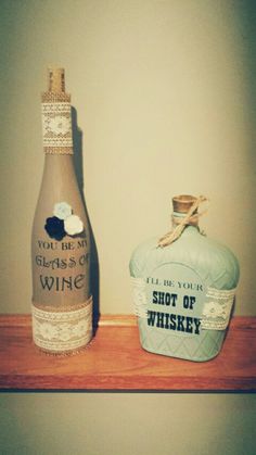 two wine bottles sitting on top of a wooden shelf next to each other, one is empty