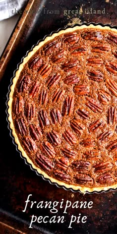 a pecan pie sitting on top of a metal pan with the words frangipane pecan pie written below it