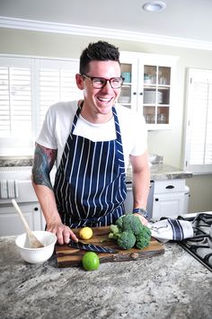 a man in an apron chopping broccoli on a cutting board