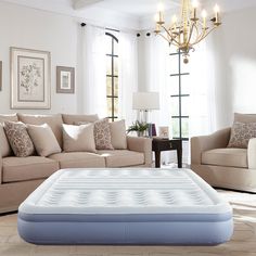 an inflatable mattress sits on the floor next to a couch and loveseat