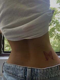 a woman with a butterfly tattoo on her lower back