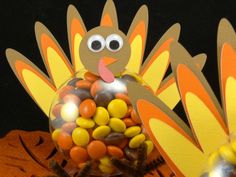 a turkey made out of candy sits in front of a pumpkin with eyes on it