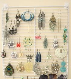 a wall mounted jewelry rack with several pairs of earrings