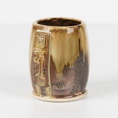 a gold and black vase sitting on top of a white table