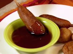 a plate with some food on it and sauce in a bowl next to the sausage