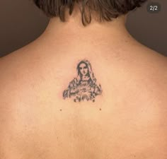 the back of a woman's neck with a tattoo on her left shoulder and an image of a virgin mary