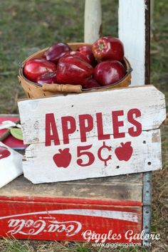 an old crate with apples on it sitting in the grass