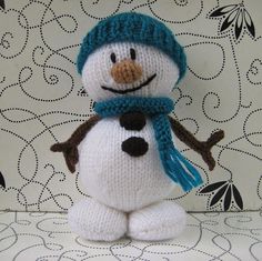 a knitted snowman with a blue hat and scarf