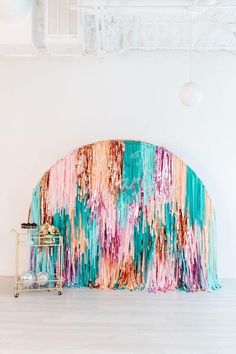 an abstractly painted couch sits in front of a white wall