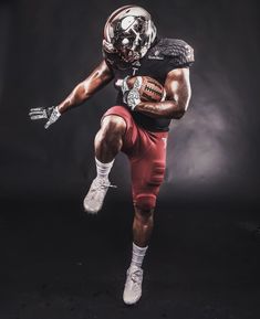 a football player wearing a uniform and holding a ball in one hand, with his foot on the ground