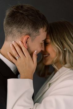 a man and woman embracing each other with their hands on their foreheads as they look into each others eyes