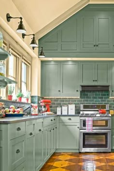 a kitchen with green cabinets and an oven in the center is decorated with checkerboard flooring