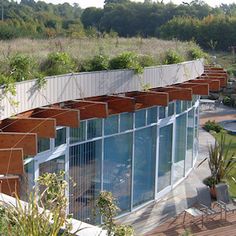 an aerial view of a building with many plants growing on the roof and side walls