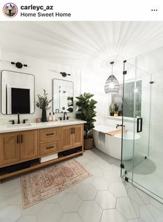 a bathroom with two sinks, a tub and a mirror on the wall above it