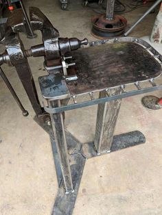 an old metal work bench in a garage with tools on the floor and around it