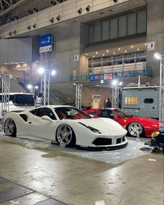 some cars are parked in a garage with lights on