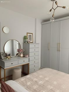 a bedroom with a dresser, mirror and dressing table in the corner next to it