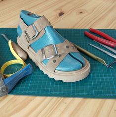 a pair of shoes sitting on top of a cutting mat