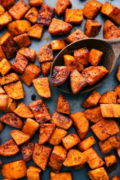 a spoon full of cooked sweet potatoes on a blue surface