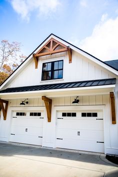 a white house with two garage doors and windows