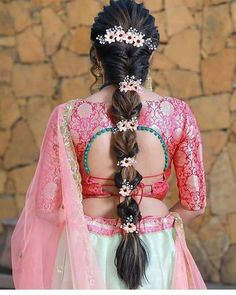 a woman in a pink and white dress with long hair braided into a pony tail